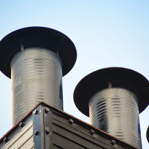 Aluminum ventilation chimneys Installed on the factory roof. Smokestack pipe for smoke out from kitchen house.